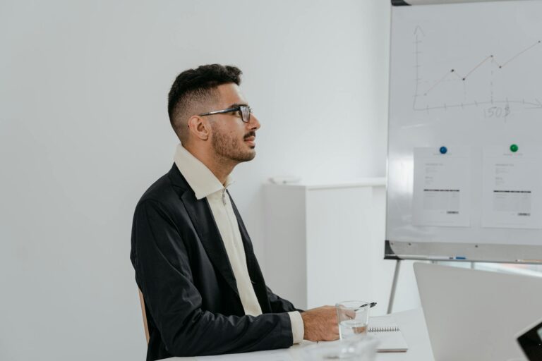Young businessman in a suit analyzing financial data during an office meeting.